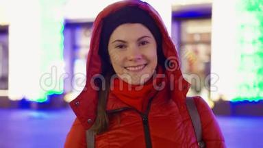 微笑的女人穿着外套站在装饰着花环的<strong>街道</strong>上。 <strong>新年</strong>圣诞节欧洲冬季